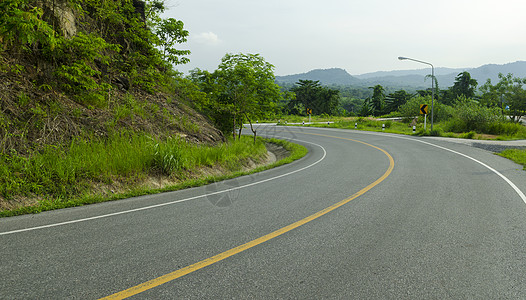 沥青道路尖锐的曲线与热带森林曲折前进背景图片