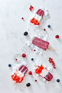 三色草莓覆盆子冰淇淋冰棒冰与浆果大理石背景,顶部视图三色自制草莓冰棒冰上与浆果大理石背景,顶部视图图片