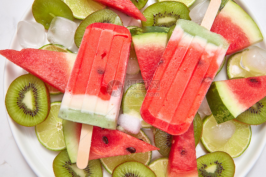 西瓜冰淇淋棒棒糖盘子上水果片冰块机冰淇淋,背景白色的健康的夏季甜点平躺健康清爽的自制冰淇淋棒棒糖个图片