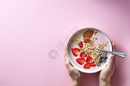 健康的冰沙白色碗与天然水果,燕麦片饼干与妇女的手着个碗粉红色的背景超级食物,自然排,饮食健康食品图片