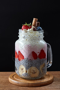 健康早餐奇亚布丁与草莓,香蕉酸奶璃梅森罐个黑暗的木制背景天然酸奶与浆果辣椒种子木制背景图片