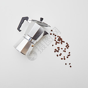 香咖啡豆金属咖啡机以倒咖啡的形式成的白色背景与平躺金属意大利咖啡机与咖啡豆的形式,倒咖啡白色背景与图片