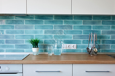 现代白色厨房家里,餐具蓝色瓷砖的背景上现代厨房家里厨房用具图片
