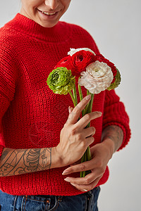 女人没脸,手里着花,白色背景上土豆美丽,时尚的穿着红色毛衣的漂亮女孩,手里着白色背景的花图片