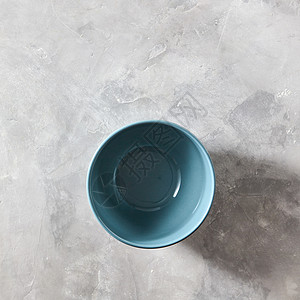 瓷器图案蓝色手工制作的中国碗蓝色灰色石材背景与平躺蓝色瓷碗隔离石灰色的背景上,平躺着背景