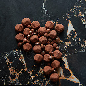 粉大理石各种黑巧克力松露与可可粉饼干黑暗的大理石背景各种黑巧克力松露背景