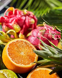 异国情调的热带背景与火龙果,半的橙色水中滴个大的棕榈叶节食自然素食的特写镜头新鲜成熟的热带水果龙果,火图片