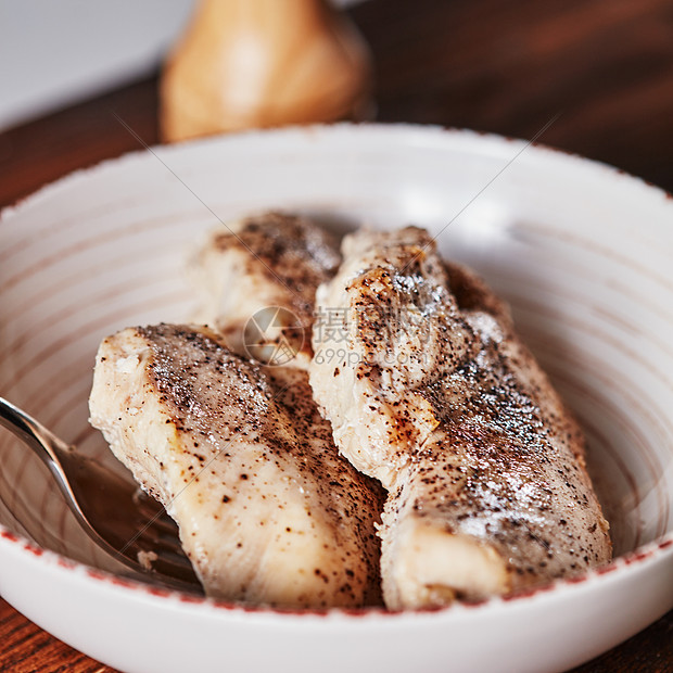 陶瓷碗叉子里用香料煮熟的鸡肉沙拉的膳食成分陶瓷碗与煮熟的鸡肉与香料叉子木桌上沙拉的配料图片