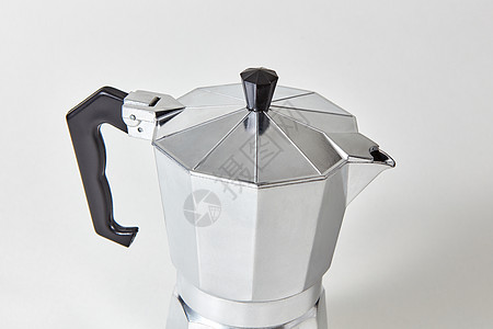 个传统的金属意大利咖啡机的特写呈现灰色的背景上金属间歇泉咖啡机的特写呈现灰色的背景上图片