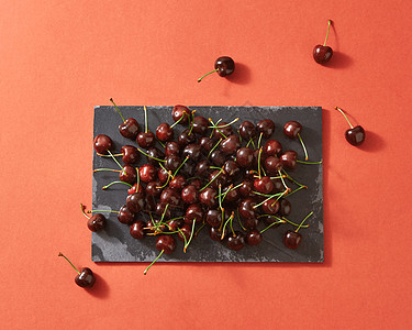 夏季浆果背景红色成熟樱桃深色石板上的颜色背景2019生活珊瑚潘通与文字的地方SPASE美味的甜樱桃黑色石板上的图片