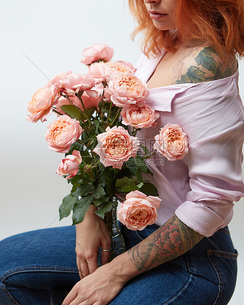 个璃花瓶与精致的粉红色玫瑰持个女孩与纹身周围的灰色背景与文字母亲节花瓶里粉红色的玫瑰,抱着个灰色背图片