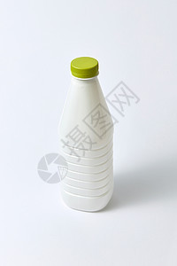 塑料空白白色瓶子,用于牛奶其他液体,绿色帽子浅灰色背景上,塑料浅背景上模拟乳制品瓶图片