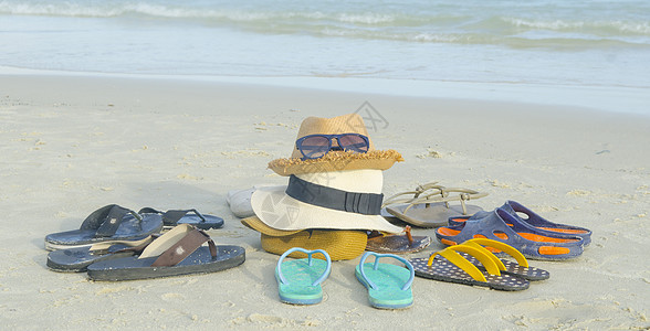 热带海滩上的草帽袋子太阳镜拖鞋图片