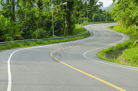 沥青道路尖锐的曲线与热带森林曲折前进背景图片