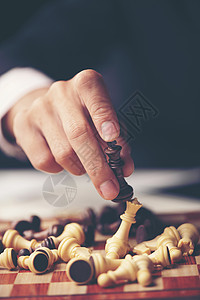 棋盘上的棋子后黑色的木头背景图片