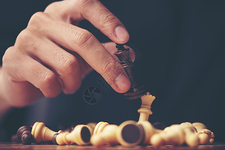 棋盘上的棋子后黑色的木头背景图片