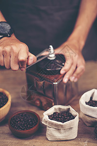 木制背景上的老式咖啡磨床豆子图片