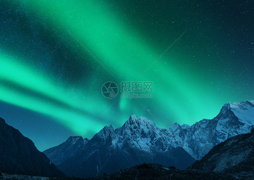 欧洲雪覆盖山脉上方的北极光冬天的北极光夜间景观与绿色极地灯雪山星空,岩石上极光图片