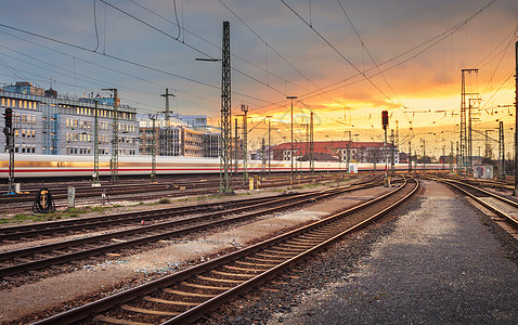 工业景观德国纽伦堡火车站铁路与高速列车五颜六色的日落美丽的天空城市建筑的背景下运动图片