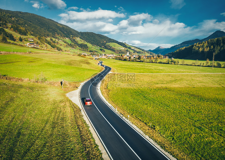 意大利白云岩春季日落时山谷道路的鸟瞰图沥青巷道汽车绿色草地蓝天树木建筑物的顶部景观公路田野自然图片