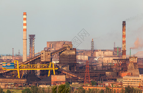 日落时烟囱的钢厂冶金厂钢铁厂,钢铁厂欧洲的重工业烟囱的空气污染,生态问题工业景观背景图片