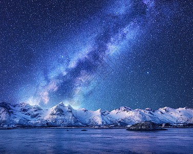 紫色的银河覆盖着挪威冬天的山脉大海风景雪岩,天空星星,倒影水中,峡湾洛芬岛美丽的银河图片
