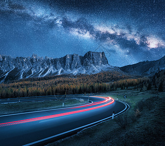 夜晚山路上的银河秋天蜿蜒的道路上模糊的汽车前灯美丽的风景,蓝色的星空,银河,轻盈的小径,岩石,树木公路秋天图片