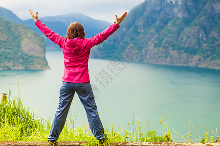 旅行快乐的自由旅游妇女幸福兴高采烈的享受与手臂伸出看着挪威的峡湾山脉挪威山区峡湾举双手的女人图片