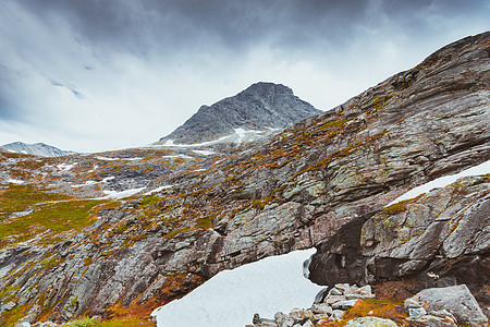寒冷的挪威景观,岩石山阴天地上的雪片寒冷的挪威景观,石头山背景图片