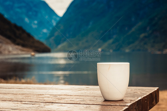 木桌上的杯子美丽的峡湾挪威斯堪的纳维亚背景,湖泊山脉木桌上的杯子,挪威峡湾景观图片