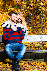 秋天爱的共同关系的阳光明媚的天,轻的浪漫夫妇坐长凳上拥抱秋天的公园情侣夫妇秋天公园的长凳上图片