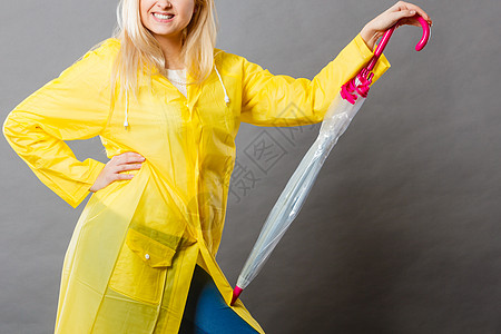 雨天配件女人手戴黄色雨衣,着紧闭的雨伞穿雨衣的女人着紧闭的伞图片