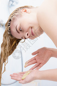 女人洗头发,洗掉洗发水,浴室里湿的金发女人湿的金发背景图片