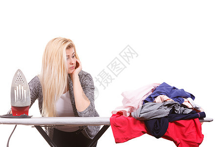 家务,照顾房子的女人站木板后着熨斗,堆衣服要熨着熨斗的女人正要熨衣服图片