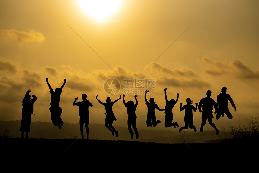 快乐的商业人力队的剪影,日落的天空,傍时间背景下,为企业队合作的理念自由高举双手图片