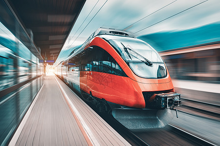 日落时火车站上的高速橙色列车运动现代城际客运列车铁路站台上运动模糊效应工业欧洲的铁路运输图片