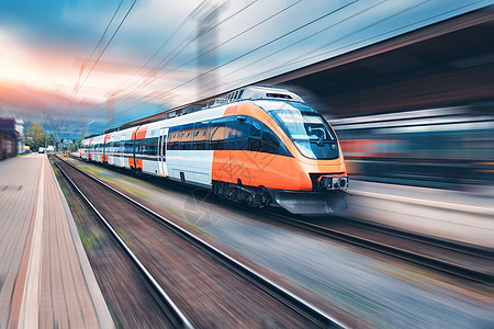 日落时火车站上的高速橙色列车运动现代城际客运列车铁路站台上运动模糊效应工业欧洲的铁路运输高速橙色列车图片