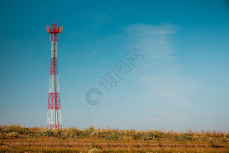 白色红色信号塔映衬着晴朗的蓝天工业自然比信号塔抗蓝天背景图片