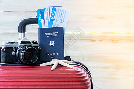 红色行李与相机护照机票海星夏季背景,蓝色木墙背景与温暖的阳光图片