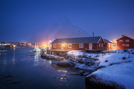 美丽的挪威罗布海上成本雪山夜间冬天挪威洛福腾群岛风景红色的房子,渔船,雪覆盖的岩石雾中,倒影水黄昏图片