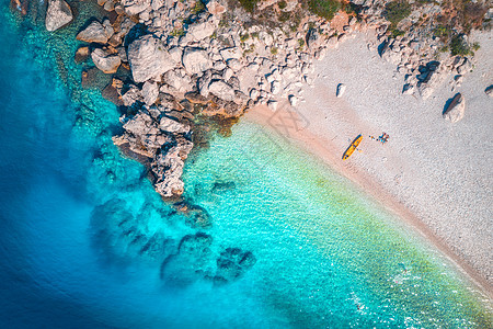 鸟瞰沙滩与夫妇独木舟,海洋与透明的蓝色水岩石阳光明媚的夏天克罗地亚旅行船的顶部视图日落时带皮艇的景观旅行图片