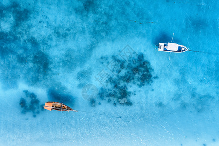 夏季日落时,清澈的蓝色大海中俯瞰渔船游艇游艇沙滩的无人驾驶飞机上俯瞰非洲桑给巴尔旅行热带景观与摩托艇,水背景图片