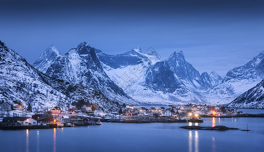 村庄里的房子,城市的灯光,雪山,大海,蓝色多云的天空冬天的夜晚反射水中风景与美丽的雷恩卢福滕岛,挪威挪威罗布黄昏图片