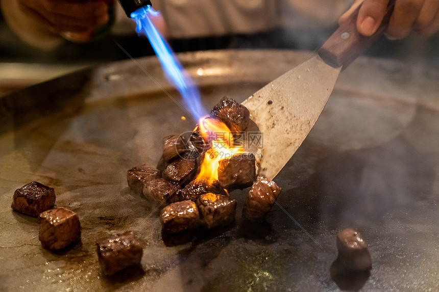 烤牛肉铁板烧食谱日本烤牛肉烹饪锅与刮刀煤气燃烧器火焰图片