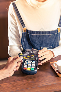 特写亚洲客户用他的信用卡与非接触式NFS技术支付咖啡师购买咖啡咖啡馆酒吧图片
