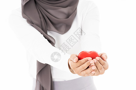 穆斯林妇女握着红色的心她的手中隔离白色背景上用保险图片