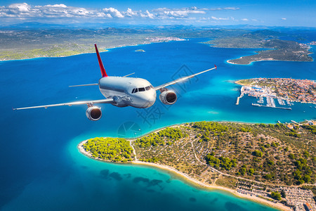 飞机在夏季日落时飞越小岛屿和海面上空图片