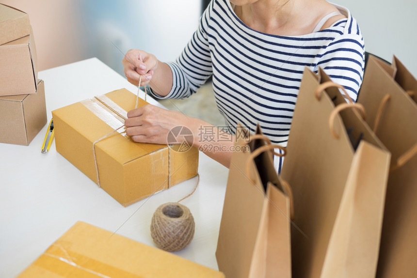 从事网上购物的拥有企业主妇女准备在家中的产品包装过程青年创业者概念图片