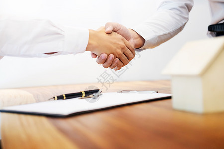 房地产代理商在签订合同作为房地产代理办事处的成功协议之后与客户握手图片