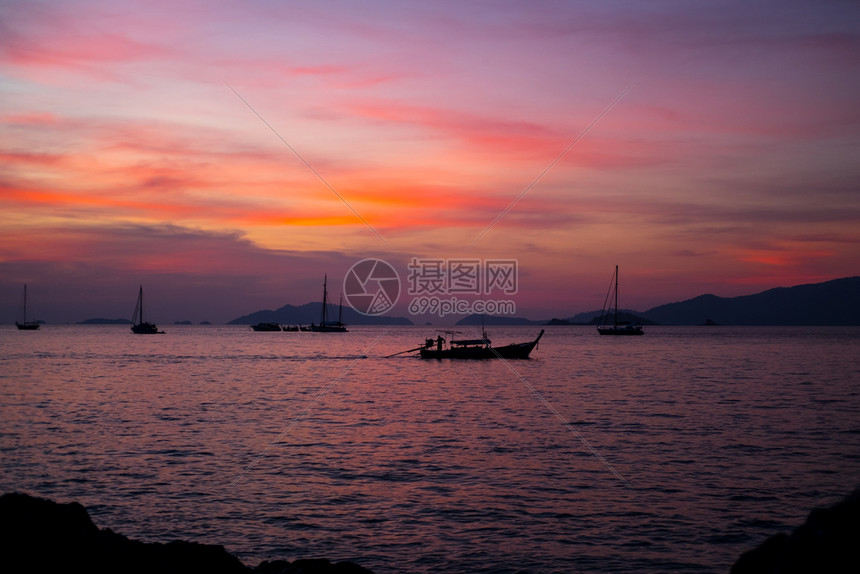 渔村的长尾帆船日落黄昏风景图图片